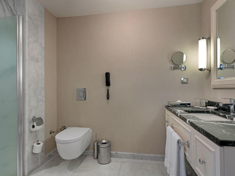 Baño limpio con inodoro, lavabo, espejo y ducha en un hotel.