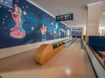 Interiér kuželnické dráhy s barevným vesmírným nástěnným malbám.