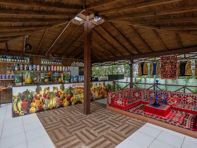 Tradiční posezení s polštáři a barevnou výzdobou v zastřešeném stánku na cestovatelském trhu.