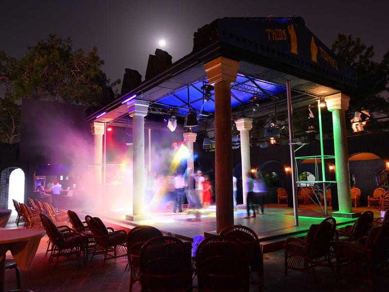 Zastřešené pódium s barevným osvětlením na hotelovém nádvoří v noci