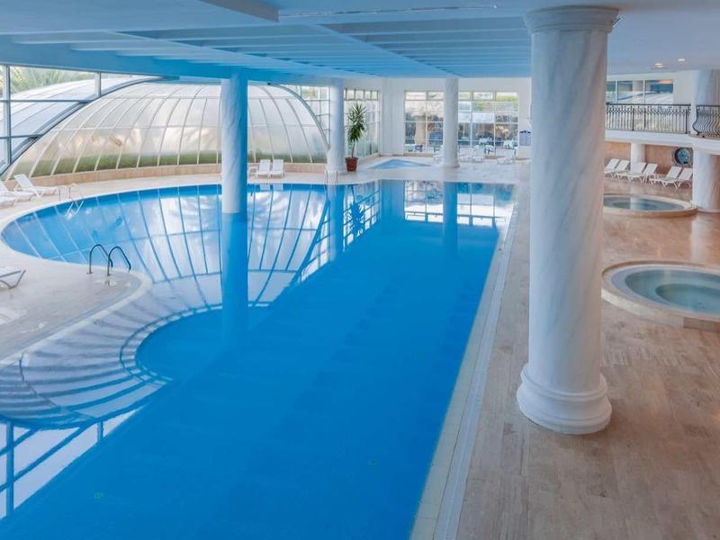 Moderne binnenzwembad met grote ramen en een whirlpool in een hotel.