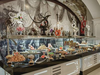 Große Vitrine mit vielfältigen kunstvollen Schokoladen- und Zuckerarbeiten in einem Café oder Laden.