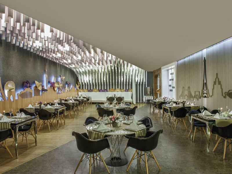 Moderní interiér restaurace s zakřiveným stropním osvětlením a elegantním stolováním.