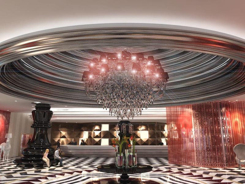 Luxusní hotelová lobby s lustrem, kruhovým stropním designem a černobílým podlahovým vzorem.