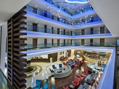 Modern hotelatrium met meerdere verdiepingen en zitgedeeltes op de begane grond