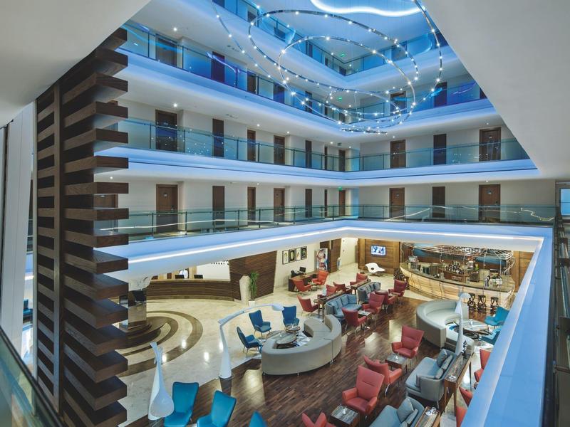 Moderne hotel lobby met open atrium en lichte zitgedeeltes.