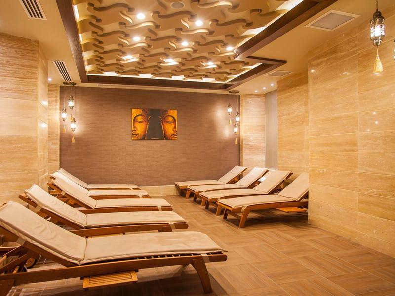 Intérieur d'une salle de repos spa paisible avec des chaises longues modernes et un éclairage chaleureux.