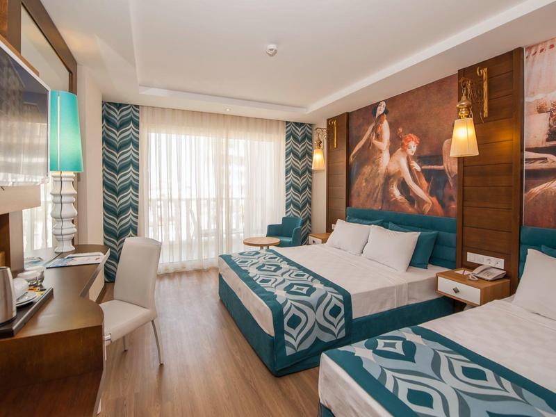 Chambre d'hôtel moderne avec deux lits, grande fenêtre et décoration élégante.