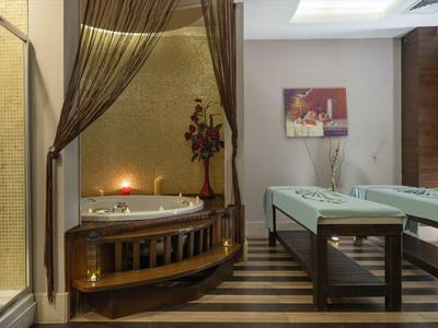 Camera d'hotel elegante con letto rotondo, doccia in vetro e tavolo da ping-pong.