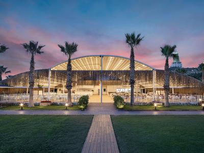Edificio moderno illuminato con palme al tramonto