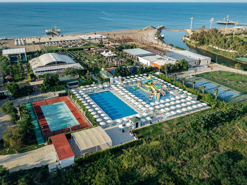 Complesso alberghiero con piscine, scivoli d'acqua e vista sul mare.