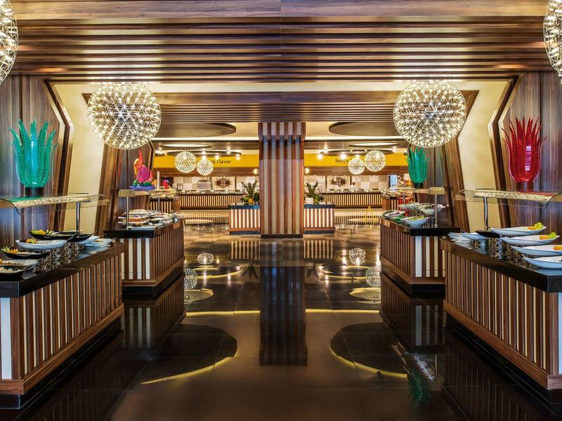 Elegantní restaurace s moderním designem, tmavou podlahou a dekorativním osvětlením.