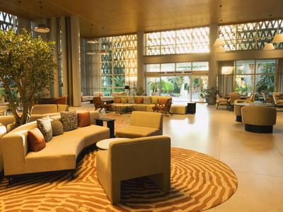 Grand hall d'hôtel avec canapés confortables, tapis et éléments en bois naturel.