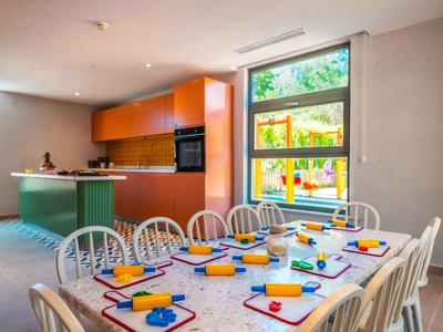 Salle de réunion lumineuse avec table de cuisine et vue sur le jardin.