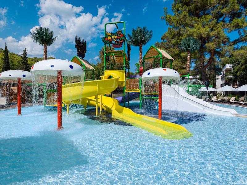 Parc aquatique avec toboggans jaunes et piscines sous un ciel bleu.