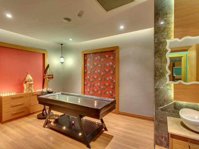 Salle de massage moderne avec table de massage en bois et décor chaleureux.