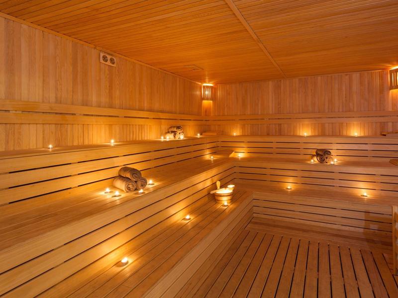 Intérieur chaleureux d'un sauna en bois avec éclairage tamisé.