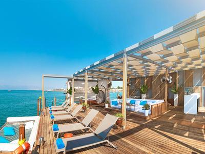 Sunny terrace with loungers and sea view at a hotel or resort.