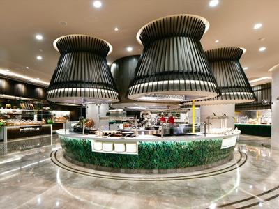 Modern buffet counter with large decorative lamps and glass cover in a stylish restaurant.
