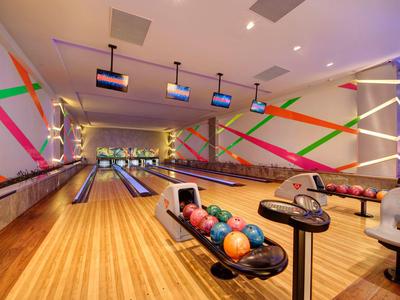 Moderne Bowlingbahn mit bunten Kugeln und weißen Spiellinien in einem Hotel.