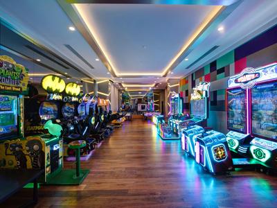Bunte Spielhalle in einem Hotel mit verschiedenen Spielautomaten und Beleuchtung.