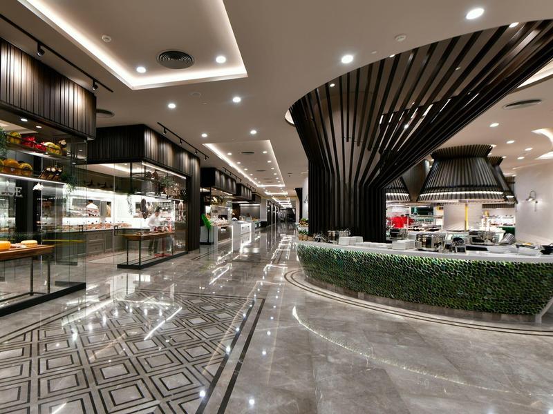 Moderne hotellobby met glanzende vloeren, strakke verlichting en luxe inrichting.