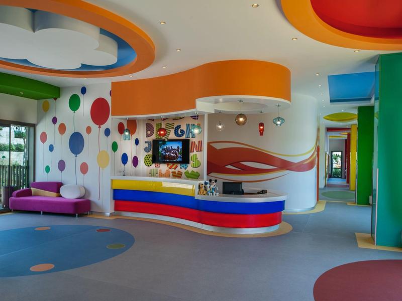 Kleurrijke hotel lobby met speelse inrichting, ronde meubels en levendige wanddecoraties.