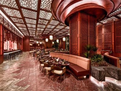 Ristorante di hotel di lusso con caldi accenti in legno e aree salotto accoglienti.