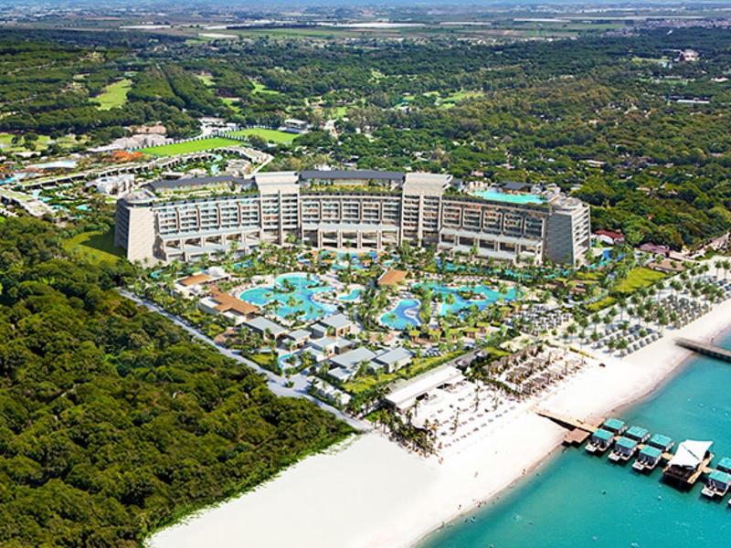 Luxury beach resort with pools and green surroundings along the coast.