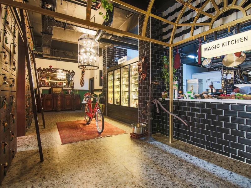 Innenraum eines Restaurants mit industriellem Design, Fahrrad, Theke und Deckenlampen aus Metall.