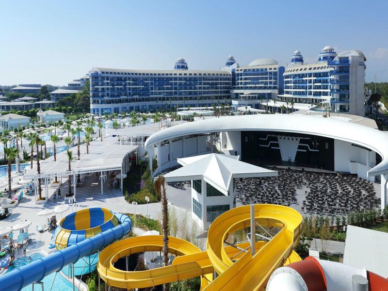 Duży hotel z zjeżdżalniami wodnymi i basenem na zewnątrz w słoneczny dzień.