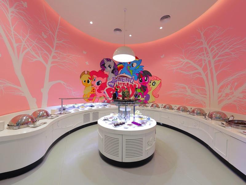 Nowoczesny, okrągły sklep jubilerski z różowymi ścianami i kolorowymi dekoracjami w centrum