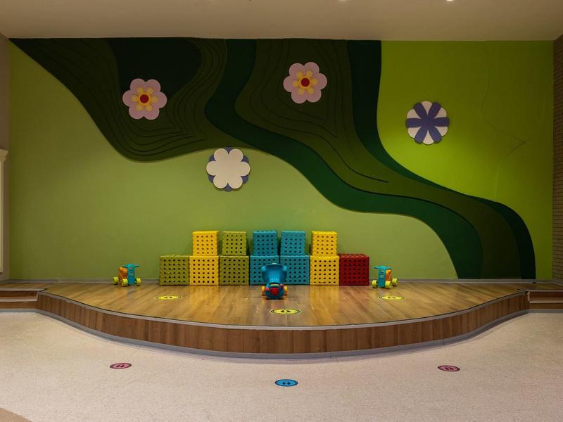 Scena z kolorowymi kostkami i kwiatowymi dekoracjami na zielonej ścianie