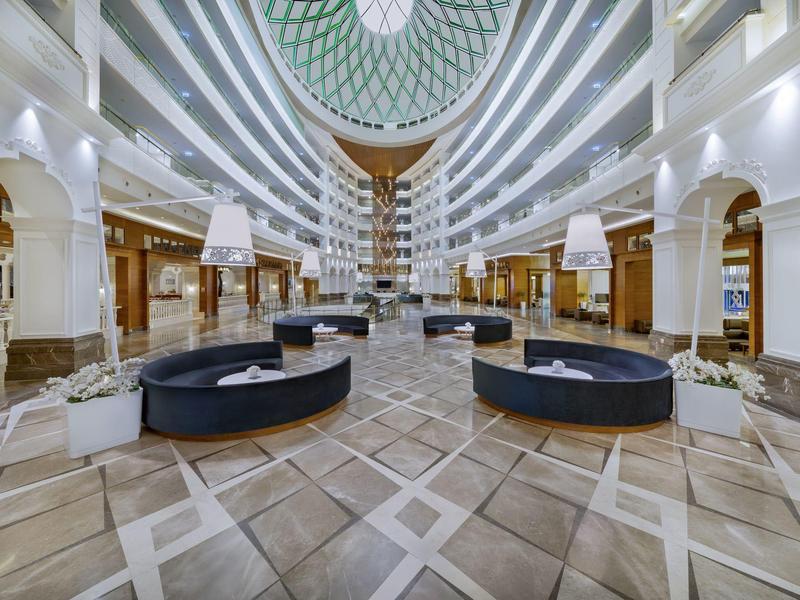 Przestronny hol hotelowy z centralnym atrium i nowoczesnym wyposażeniem