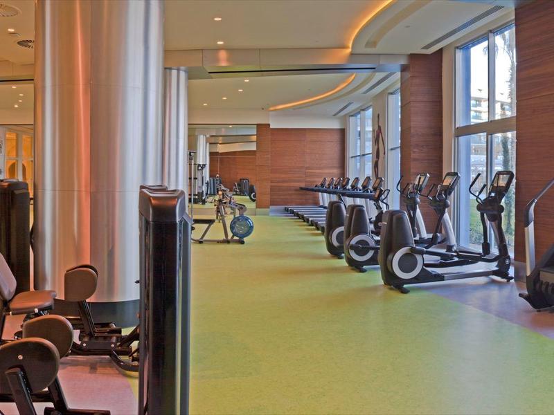 Nowoczesna sala fitness z różnymi urządzeniami do ćwiczeń i dużymi oknami