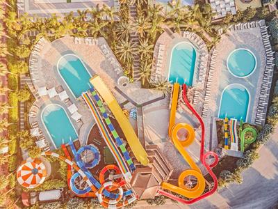 Vista aerea di un parco acquatico con piscine, scivoli d'acqua e lettini.