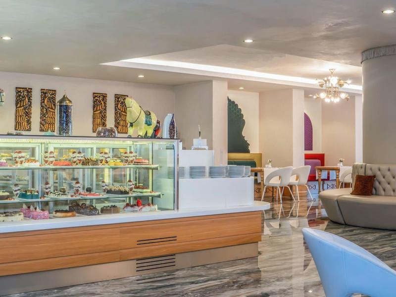 Moderne Hotellobby mit Lounge, Glastheke und Sitzbereich in heller, einladender Atmosphäre