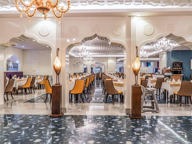 Elegantes Restaurant mit stilvollen Sitzbereichen und dekorativen Bögen in warmem Licht.