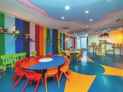Sala giochi colorata e moderna per bambini con sedie e tavoli vivaci in un hotel.