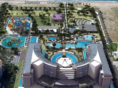 Vista aérea de un complejo con piscinas, jardines y acceso directo a la playa.