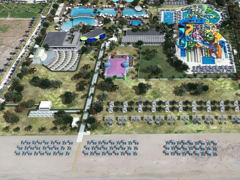 Vista aérea de un gran complejo de playa con piscinas, toboganes y acceso directo a la playa.