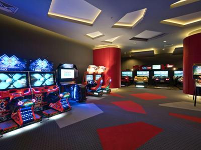 Sala giochi ben illuminata con videogiochi e sedili colorati.