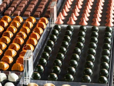 Anordnung von bunten Pralinen in Reihen auf einem Display im Hotel oder Laden.