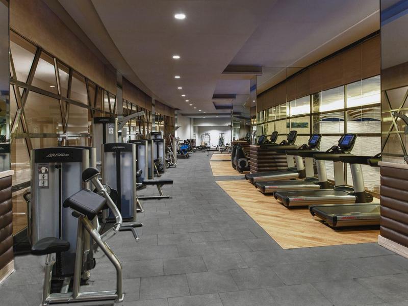 Großer moderner Fitnessraum mit verschiedenen Trainingsgeräten und Laufbändern