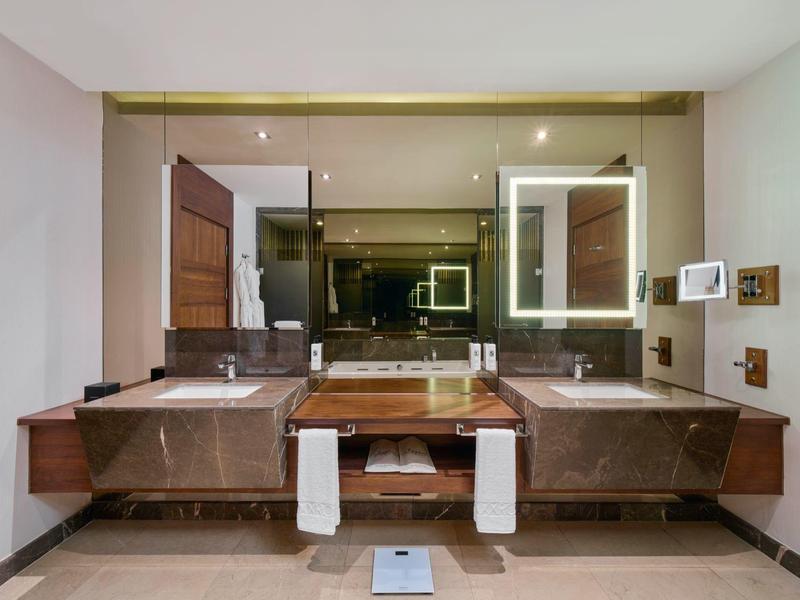 Luxuriöses Badezimmer mit zwei Waschbecken, großen Spiegeln und modernen Armaturen.