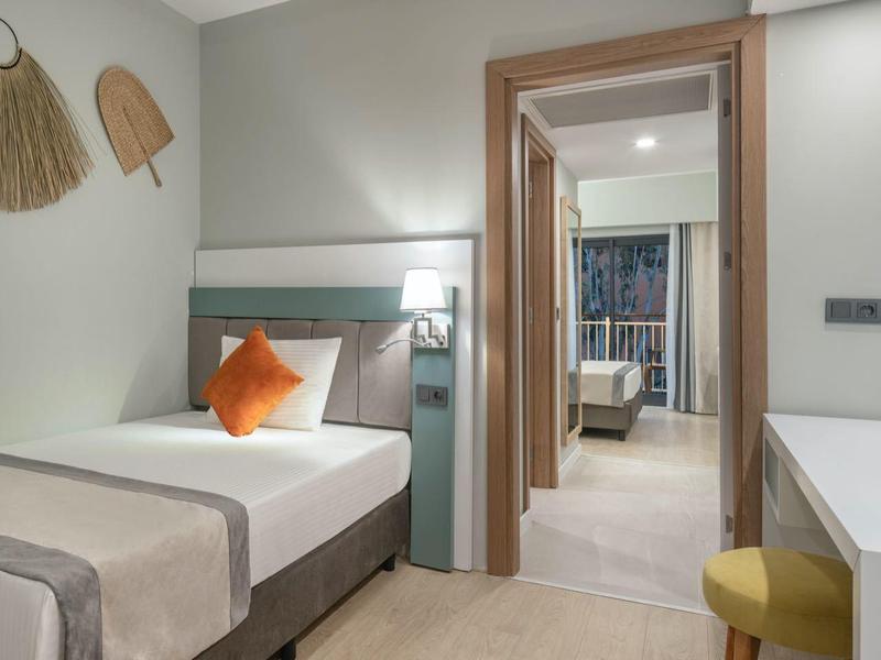 Moderne hotelkamer met eenpersoonsbed, bureau, tv en decoratieve wandversieringen.