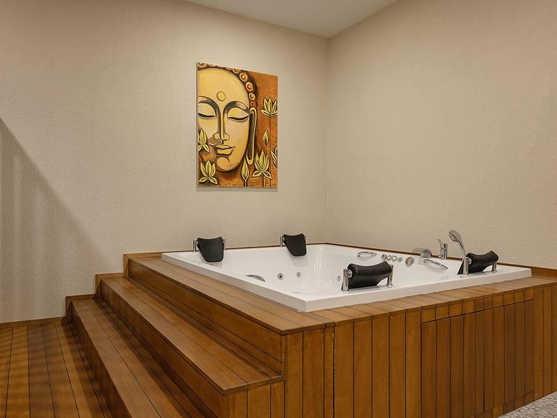 Whirlpool met houten bekleding in een neutrale, moderne omgeving met wanddecoratie.