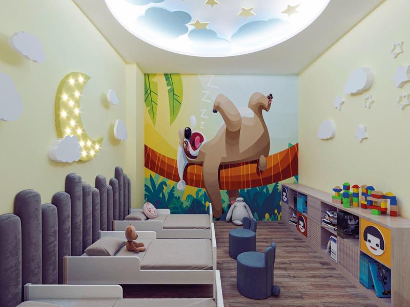 Kleurrijke kinderspeelruimte met bedden, wanddecoraties en speelgoed in hotelkamer.