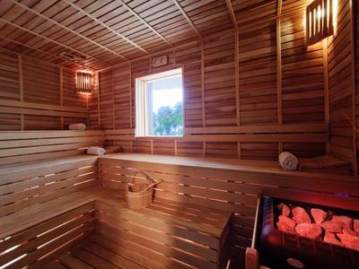 Helle, gemütliche Sauna mit Holzverkleidung, Sitzbänken und erhitztem Saunaofen.