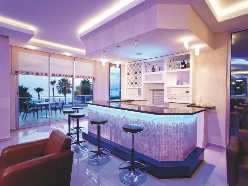 Bar moderno con taburetes altos y vista al mar desde un área interior iluminada